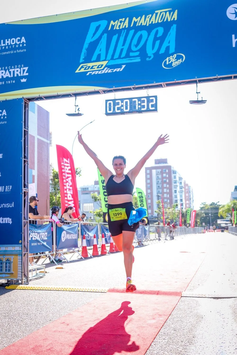 Atleta cruza o pórtico de chegada de braços erguidos